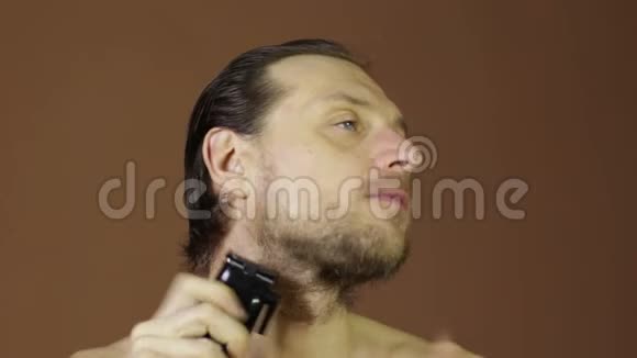 男人用电动剃须刀剪脸大胡子视频的预览图