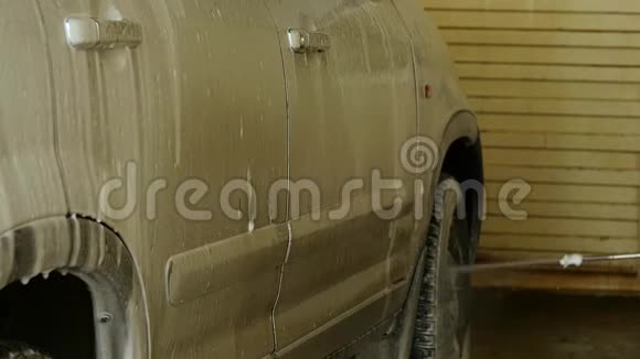 泡沫从车里滴下来在洗车服务中清洗汽车慢动作视频的预览图