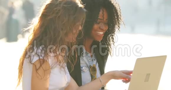 多民族女朋友用笔记本电脑发短信聊天上网的特写镜头视频的预览图