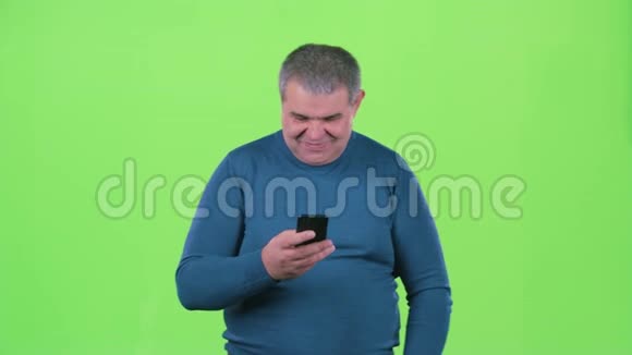 成年男子正在看电话留言绿色屏幕视频的预览图