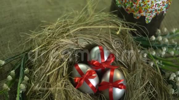 鸟巢和复活节蛋糕的红色丝带银蛋的俯视图滑块拍摄视频的预览图