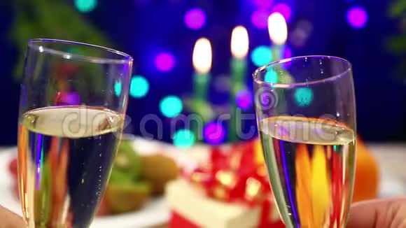 一个男人带着一个女人用香槟碰杯一个特写在一张有礼物的桌子的背景上有杰兰灯视频的预览图