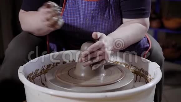 陶器大师在电动陶工轮的平台上拉伸和揉捏粘土视频的预览图