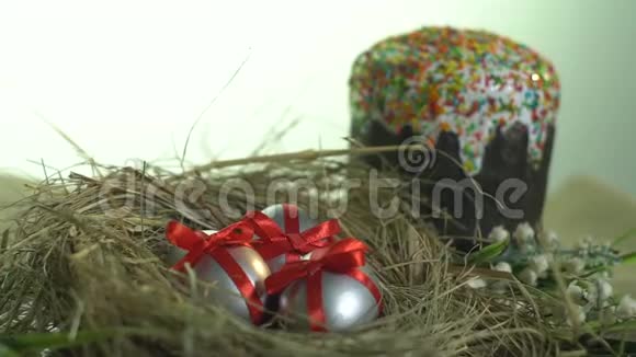 银蛋系丝带躺在巢中背景是节日蛋糕滑盖拍摄视频的预览图