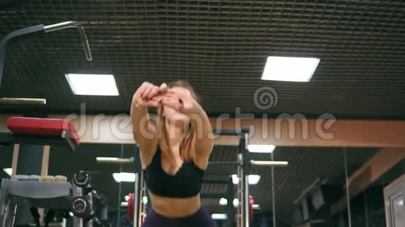 一位身材矮小的年轻女子在健身房做深蹲改善了臀部和腿部的肌肉视频的预览图