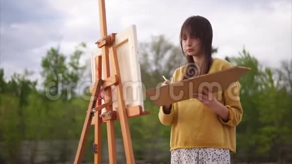 一个成年女人拿着油画颜料画着静物视频的预览图