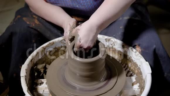 工匠正在用旋转的车轮头制作陶瓷壶用手除去多余的粘土以使陶器的形状更精细视频的预览图