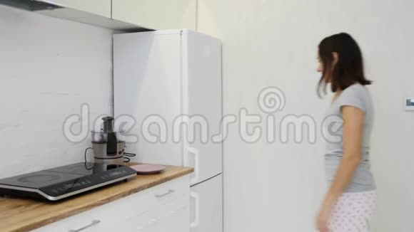 从冰箱里拿食物的年轻女人视频的预览图