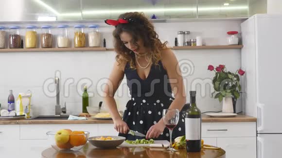 女人在家庭厨房的木制厨房板上切奇异果在家做饭厨房里的家庭气氛视频的预览图