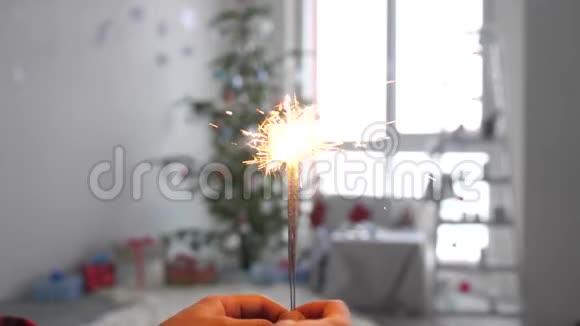 女孩的手圣诞树前燃烧的火花慢动作3840x21604k视频的预览图