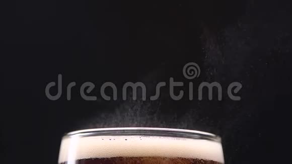 碳酸可乐在玻璃上喷射气体在黑色背景上关门视频的预览图