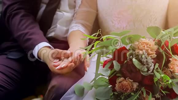 新郎新娘的特写镜头坐着手牵手新郎握着新娘手视频的预览图