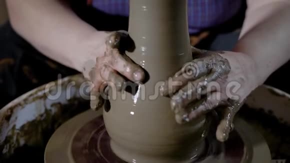 手工陶瓷生产的大师是投掷和拉粘土以塑造未来花瓶的墙壁均匀厚度视频的预览图