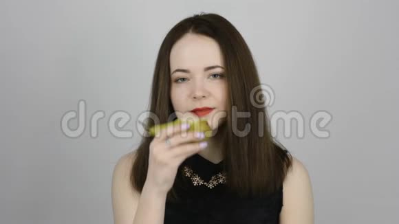 迷人的年轻女子吃着绿梨微笑着视频的预览图