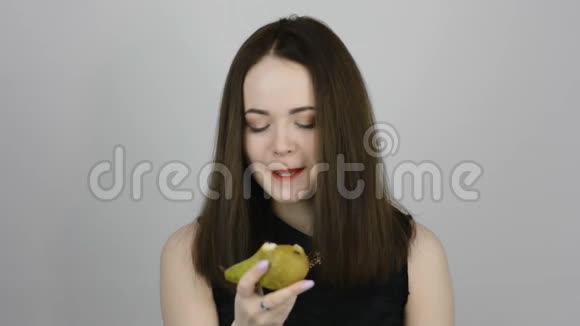 迷人的年轻女子吃着绿梨微笑着视频的预览图