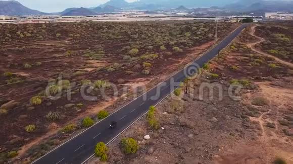 在沙漠公路上行驶的摩托车手的鸟瞰图视频的预览图