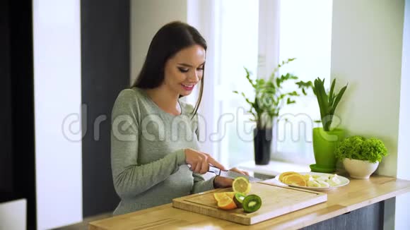 健康的生活方式在厨房切新鲜水果的女人视频的预览图