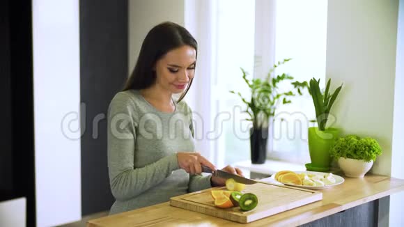 健康的生活方式在厨房切新鲜水果的女人视频的预览图