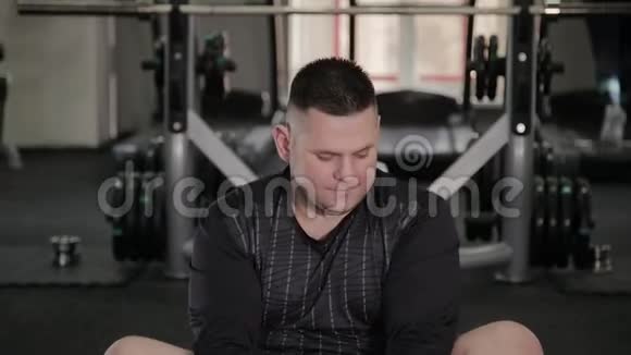 胖子在健身房地板上做伸展运动视频的预览图