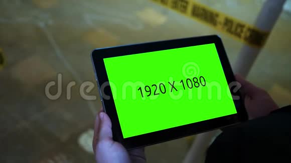 犯罪现场调查员手持绿屏平板电脑积极调查视频的预览图