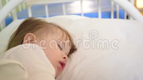 小孩子睡在枕头上特写镜头迷人的婴儿在家里的房间里的白色床上睡着了概念视频的预览图