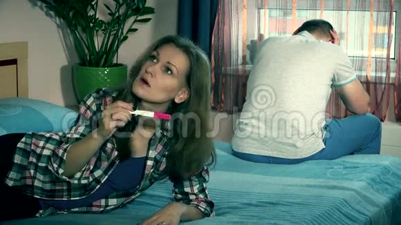 怀孕后沮丧的女人和男人坐在卧室的床上视频的预览图