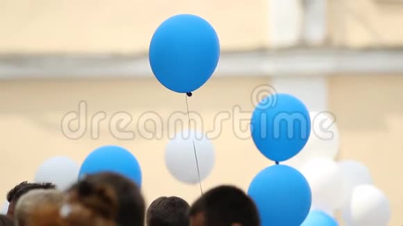 毕业典礼上人们举着五颜六色的气球向学生表示祝贺视频的预览图