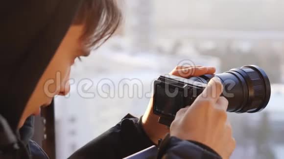 年轻人调整窗口背景上的照相机视频的预览图