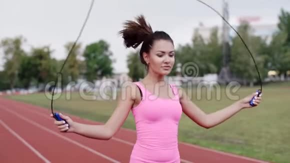 一个穿着粉红色球衣的女孩跳上一根绳子视频的预览图