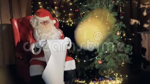 圣诞老人在圣诞树旁阅读圣诞祝福清单4公里视频的预览图