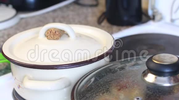 一个人检查意大利面的准备情况把锅盖从锅里拿出来勺子搅动里面的东西视频的预览图