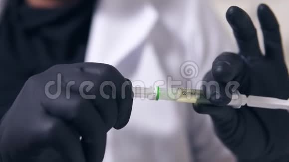 职业医生用黑色手套双手握着医用注射器准备注射视频的预览图