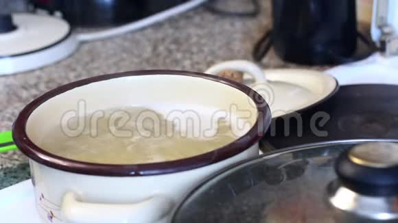 一个人检查意大利面的准备情况把锅盖从锅里拿出来勺子搅动里面的东西视频的预览图