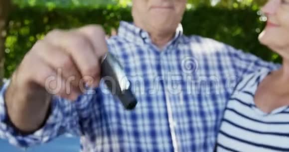 一位年长的男子展示高级女子的汽车钥匙视频的预览图