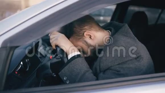 一位留胡子的年轻商人坐在车里在严重的故障和交通堵塞后感到非常沮丧和压力视频的预览图