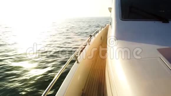 游艇驶向夕阳用悬挂的帆和柚木甲板航行船甲板库存乘游艇出海视频的预览图