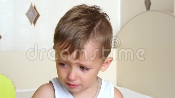 小男孩哭着坐在高高的椅子上视频的预览图