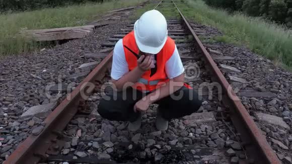 对讲机上的铁路工人检查铁轨上的漏油情况视频的预览图