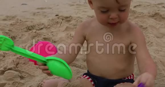 可爱的小男孩在玩沙滩玩具视频的预览图