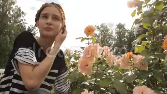女孩在公园里闻玫瑰视频的预览图