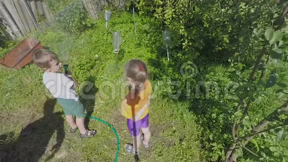 孩子们在乡间小屋院子里给植物浇水视频的预览图