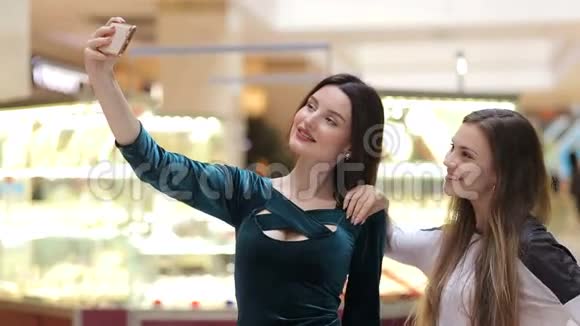 女孩们在购物中心的手机上自拍视频的预览图