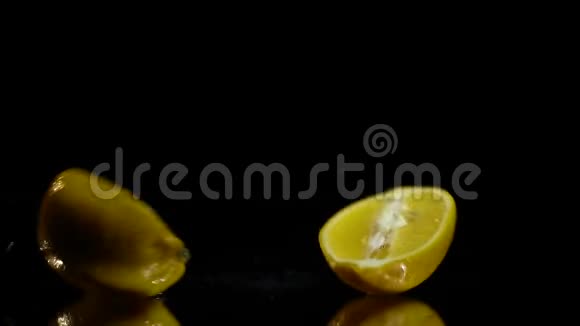 切好的柠檬落在镜子上的黑色背景上视频的预览图