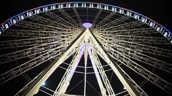 巨型摩天轮在主题公园的背景下慢慢旋转视频的预览图