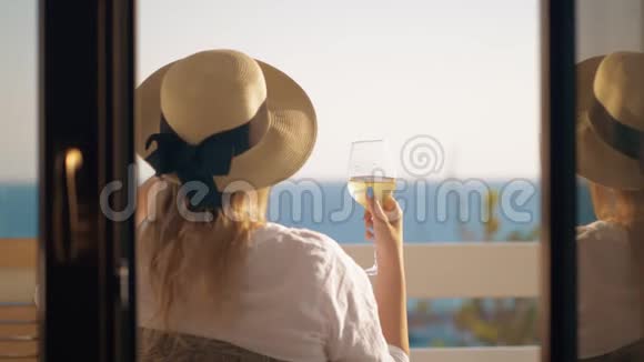 女人喝着酒在俯瞰大海的阳台上放松视频的预览图