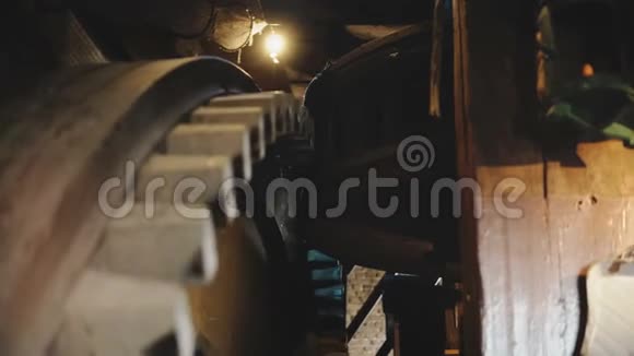 4巨大的木制风车齿轮慢慢转动传统的老荷兰磨坊机构内的特写齿轮旋转视频的预览图