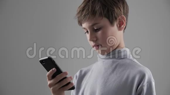 青少年儿童在白色背景下使用智能手机的肖像视频的预览图