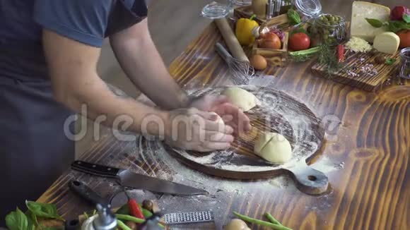 男性手做面团做馅饼烘焙厨师在木板上揉面准备披萨烹饪视频的预览图