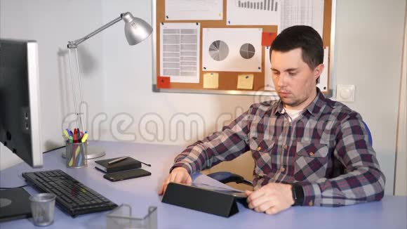 商人坐在办公室里检查平板电脑上收到的邮件视频的预览图