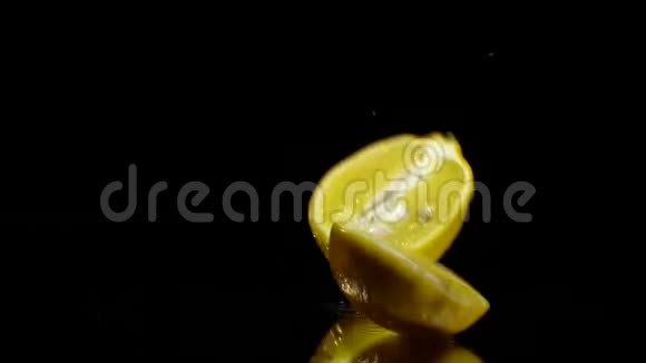 一个半柠檬落在黑底镜上有点慢动作视频的预览图